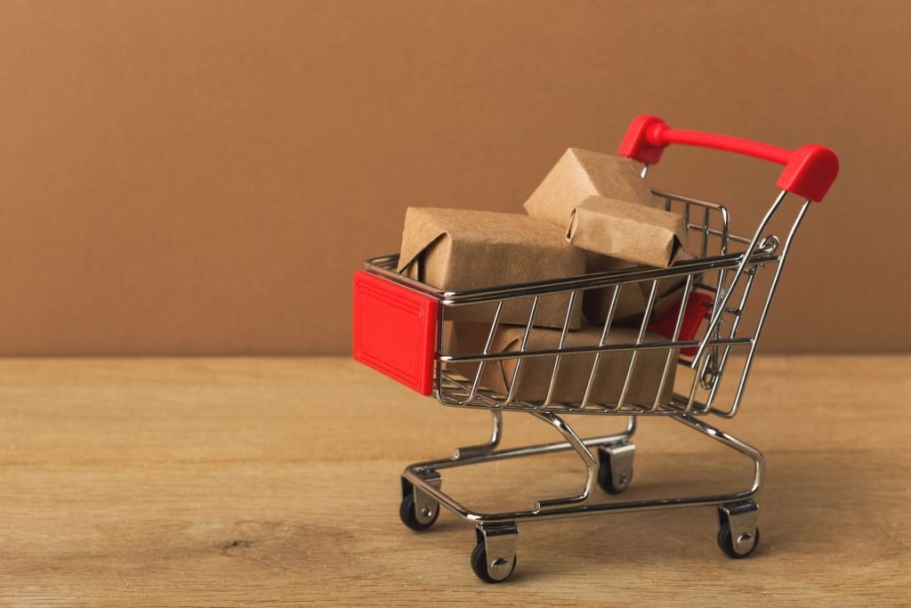 miniature-shopping-cart-and-parcels-on-brown-backg-2022-12-16-08-14-42-utc (2) (1)