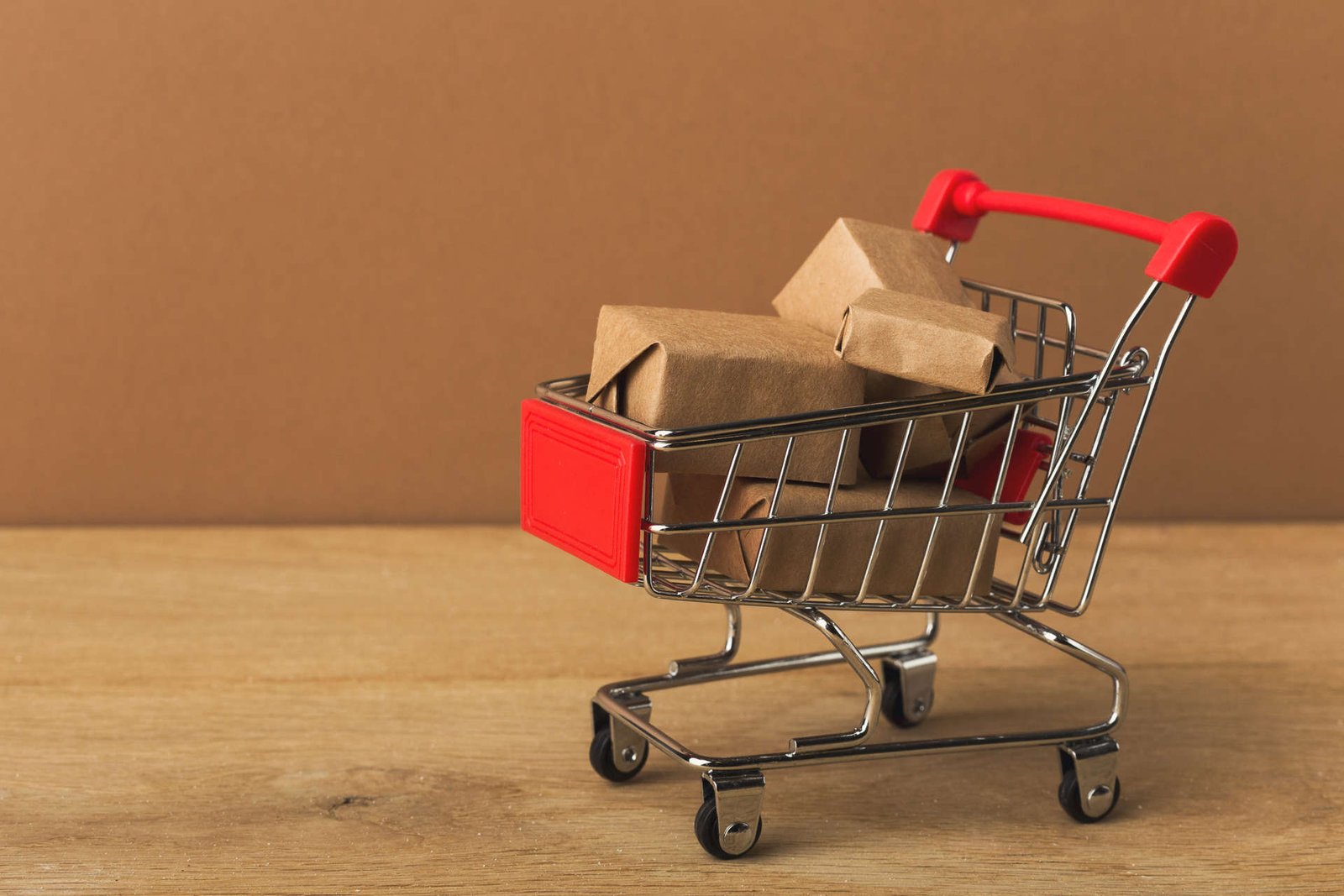 miniature-shopping-cart-and-parcels-on-brown-backg-2022-12-16-08-14-42-utc (2) (1)